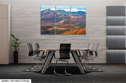a modern office space with a large, three-panel landscape painting of a mountainous, desert-like scene hanging on the wall above a conference table surrounded by chairs.