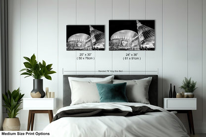 a bed with a white comforter and two black and white pictures on the wall