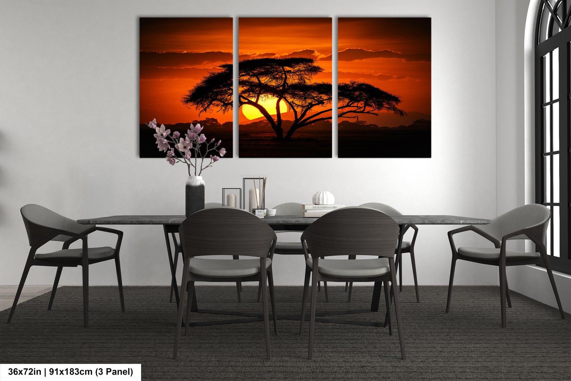 a dining room table with four chairs and a painting of a tree