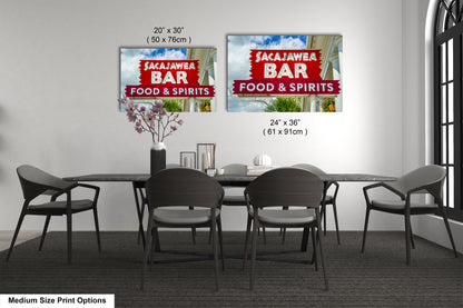 a dining room table with four chairs and a sign on the wall