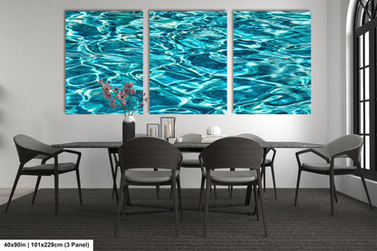 a modern dining room with a large, three-panel artwork depicting a serene water scene. The artwork is displayed on the wall above a black dining table surrounded by six chairs. The room has a minimalist and contemporary design, with a gray carpet and a white wall.