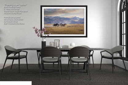 a dining room table with chairs and a picture hanging on the wall