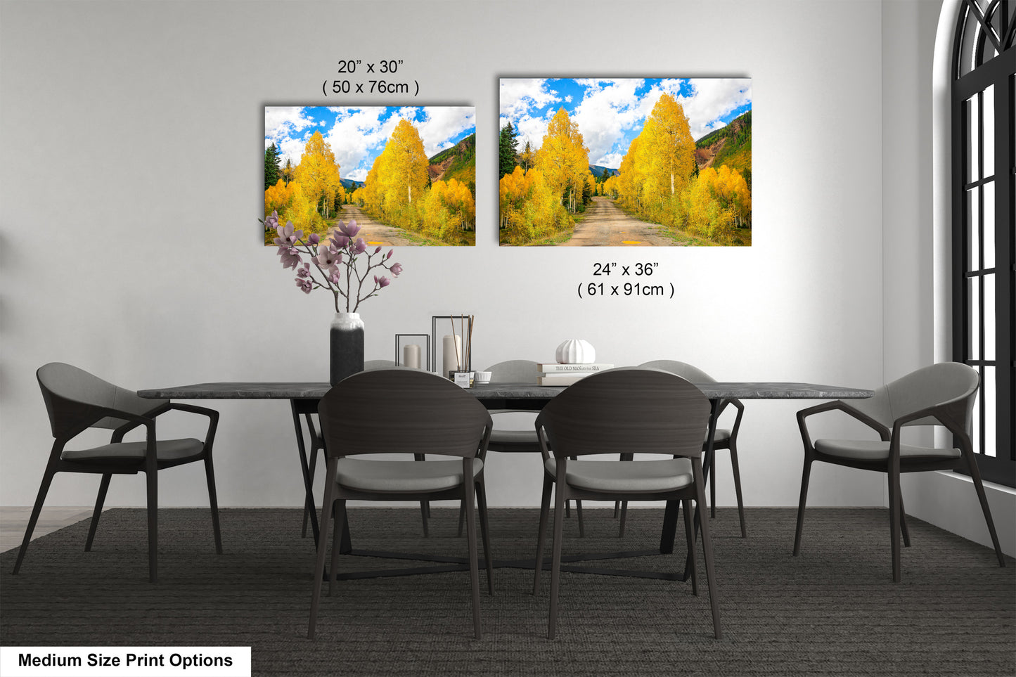 a dining room table with four chairs and two pictures on the wall