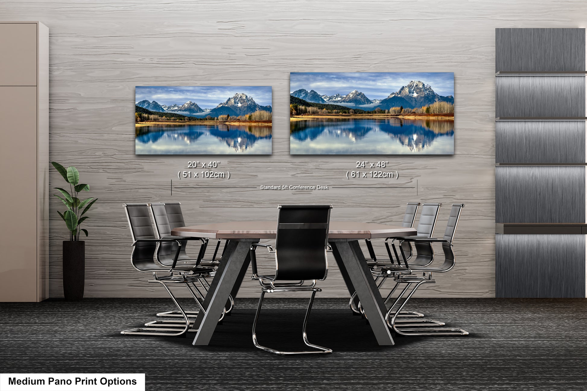 a modern office space with a large wall displaying two framed landscape paintings depicting a serene mountain lake scene. The paintings are hung at eye level, creating a focal point in the room. The office space includes a wooden table surrounded by chairs, and a potted plant is visible in the corner.