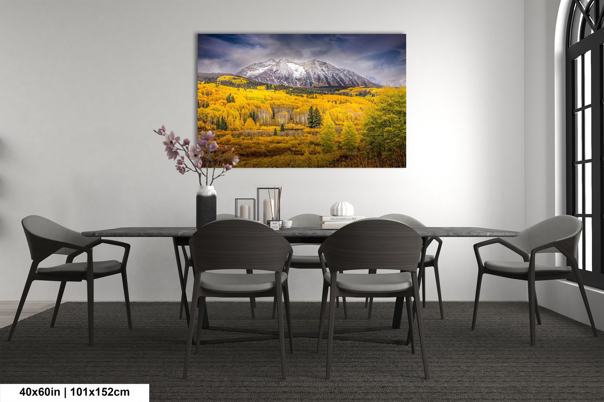 a dining room table with chairs and a painting on the wall