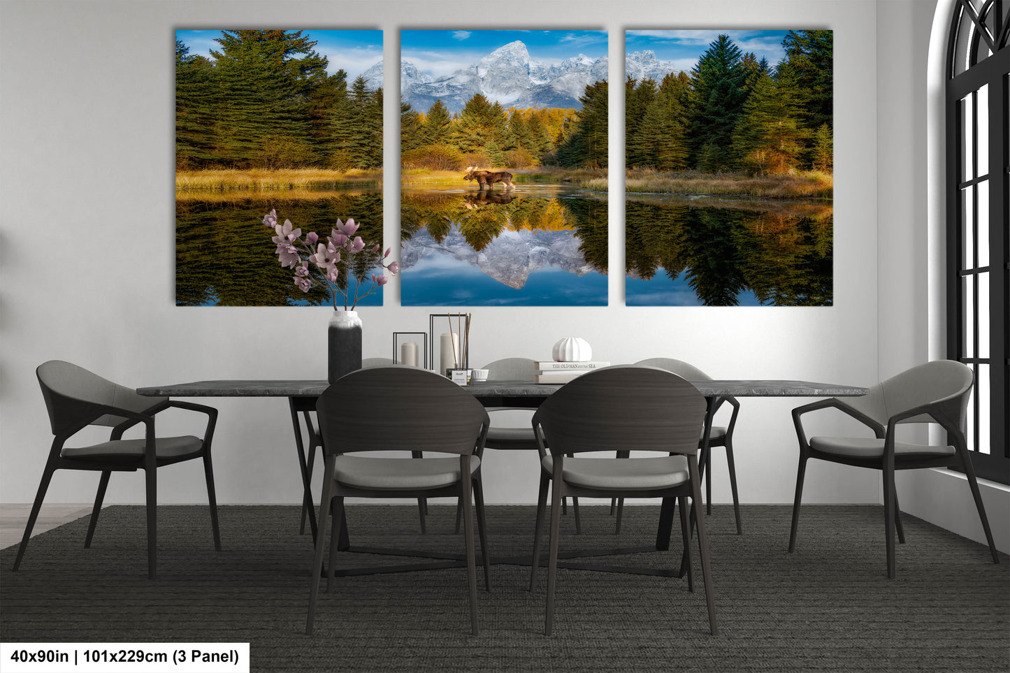 a dining room table with four chairs and three paintings on the wall