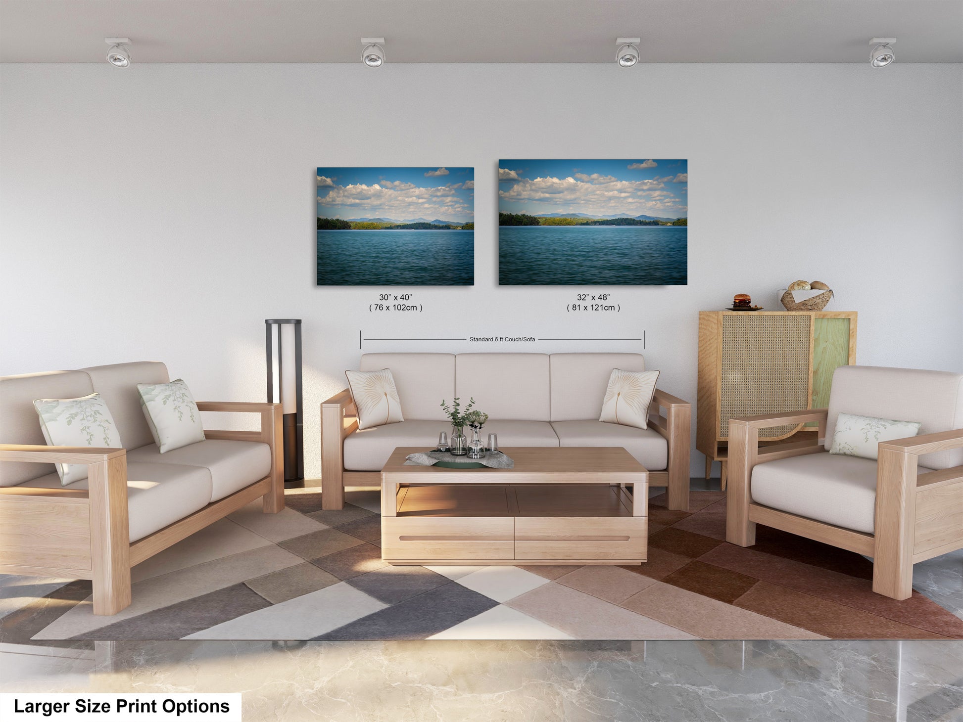 a modern living room with a large sofa, two chairs, and a coffee table. There are two framed landscape paintings on the wall above the seating area, depicting a serene lake and a blue sky with clouds. The room has a neutral color scheme with white walls and a wooden floor.