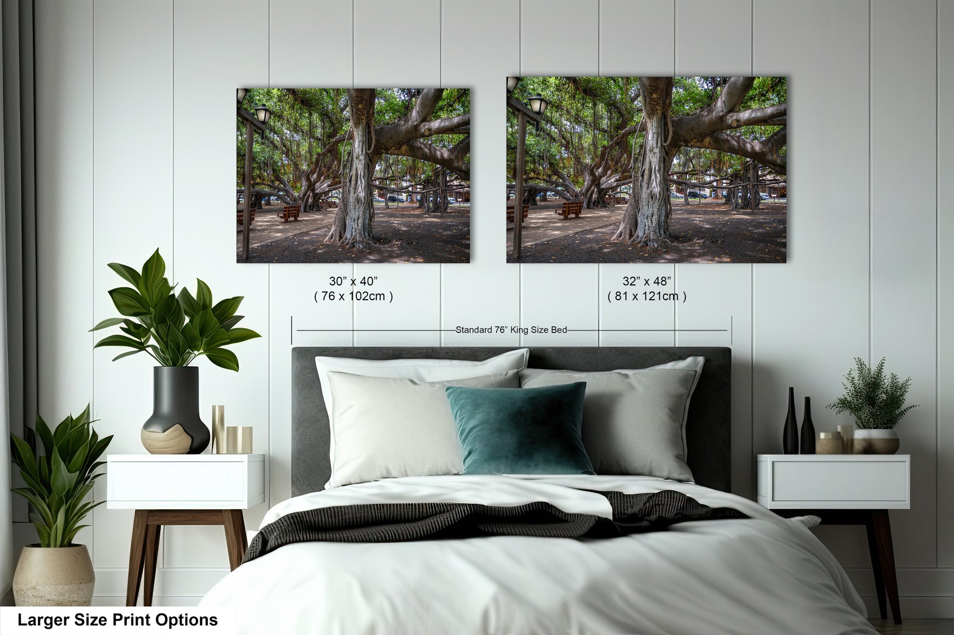 a bed with two pictures of trees on the wall above it