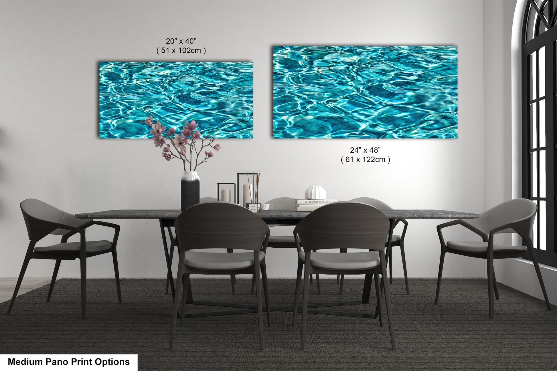 a modern dining room with a black table and chairs, and two large framed prints of water on the wall above the table.