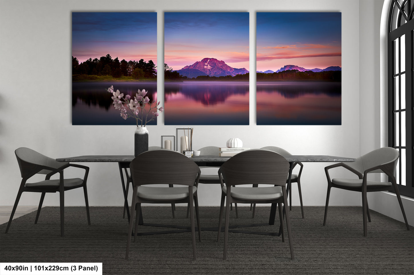 a dining room table with four chairs and three paintings on the wall