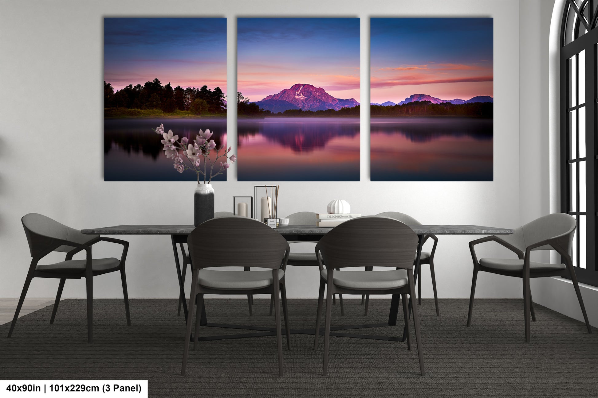 a dining room table with four chairs and three paintings on the wall