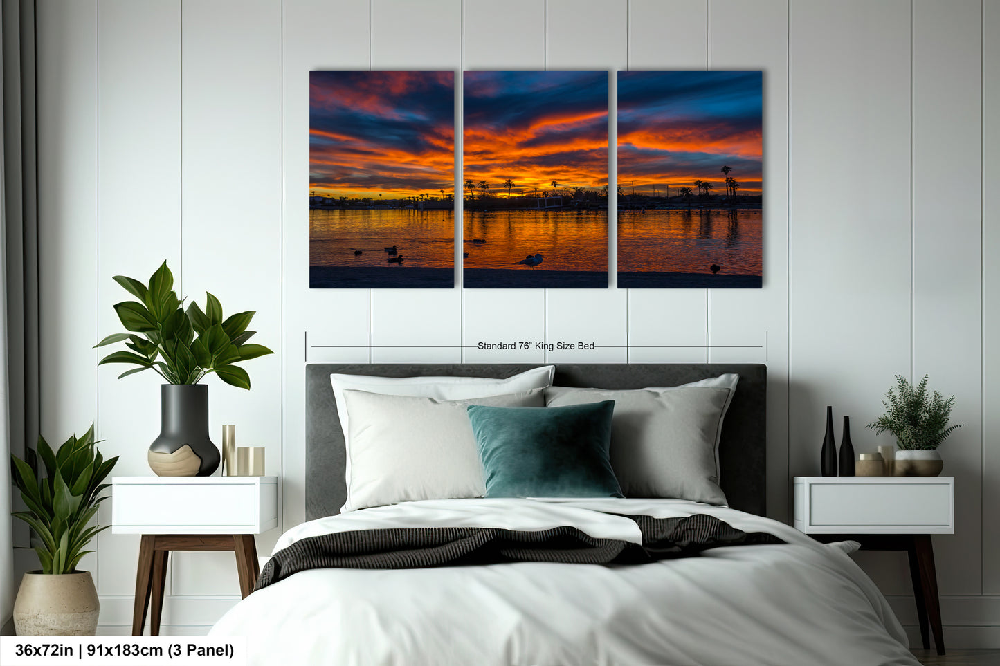 A bedroom with a large bed, nightstands, and a large wall art depicting a sunset over a body of water.