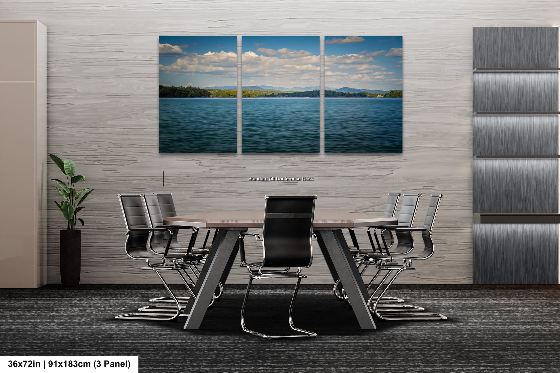 A modern office space with a large, three-panel landscape painting depicting a serene lake and sky above it. The painting is mounted on a gray wall above a wooden table surrounded by black chairs.