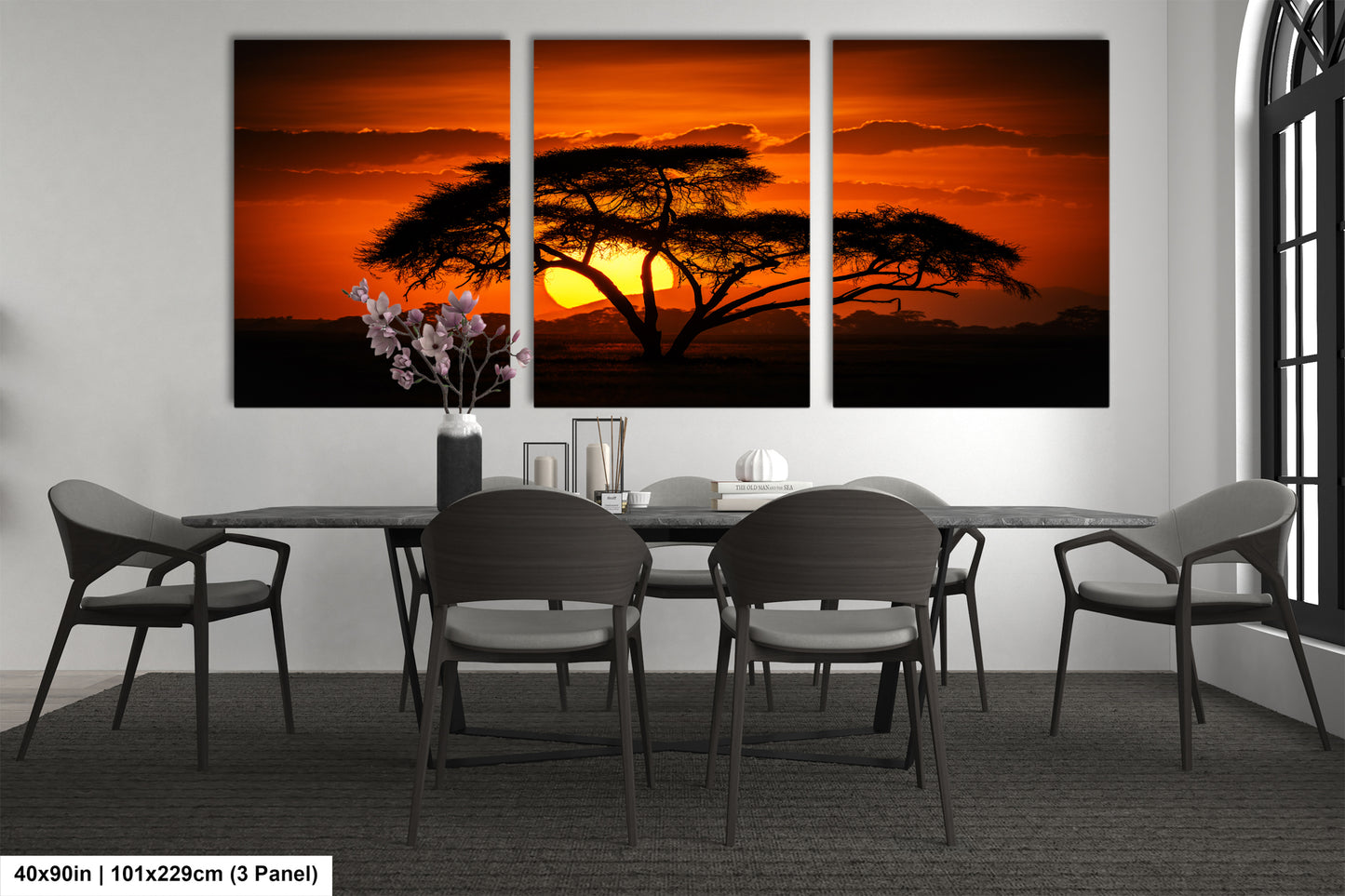 a dining room table with four chairs and a painting of a tree