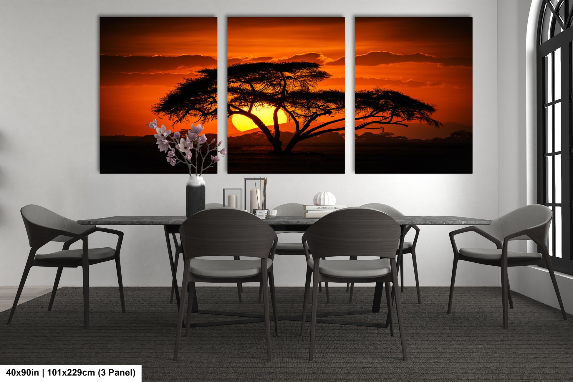 a dining room table with four chairs and a painting of a tree