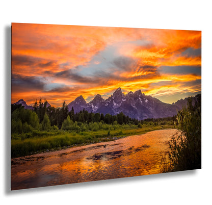 a river running through a lush green forest under a colorful sky