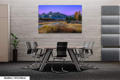 a dining room table with a painting of a mountain range in the background