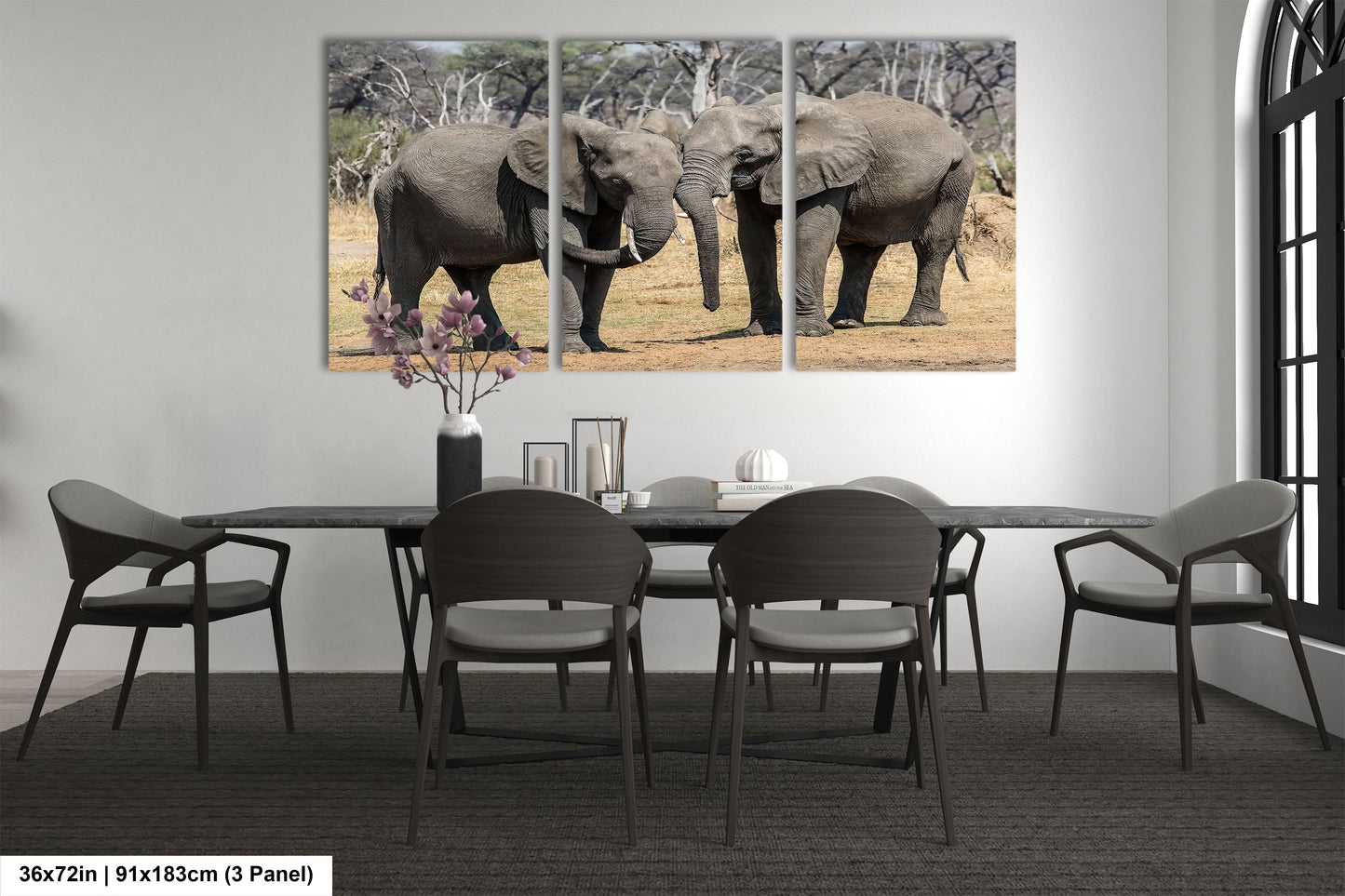 a dining room table with chairs and two elephants on the wall