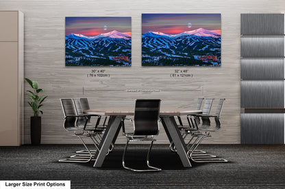 a dining room table with chairs and two pictures of mountains