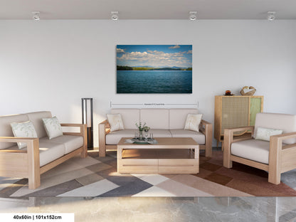 a modern living room with a large painting of a serene lake scene hanging on the wall. The room is furnished with a sofa, two armchairs, and a coffee table, creating a comfortable and inviting atmosphere.