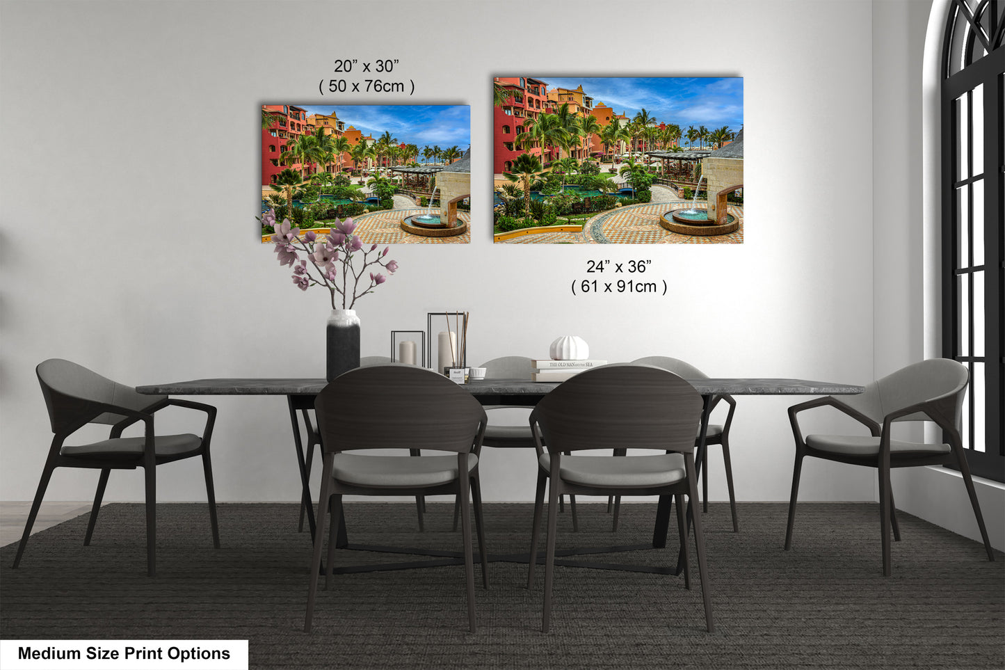 a dining table with four chairs and a vase of flowers
