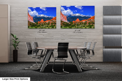 a dining room table with chairs and two pictures on the wall