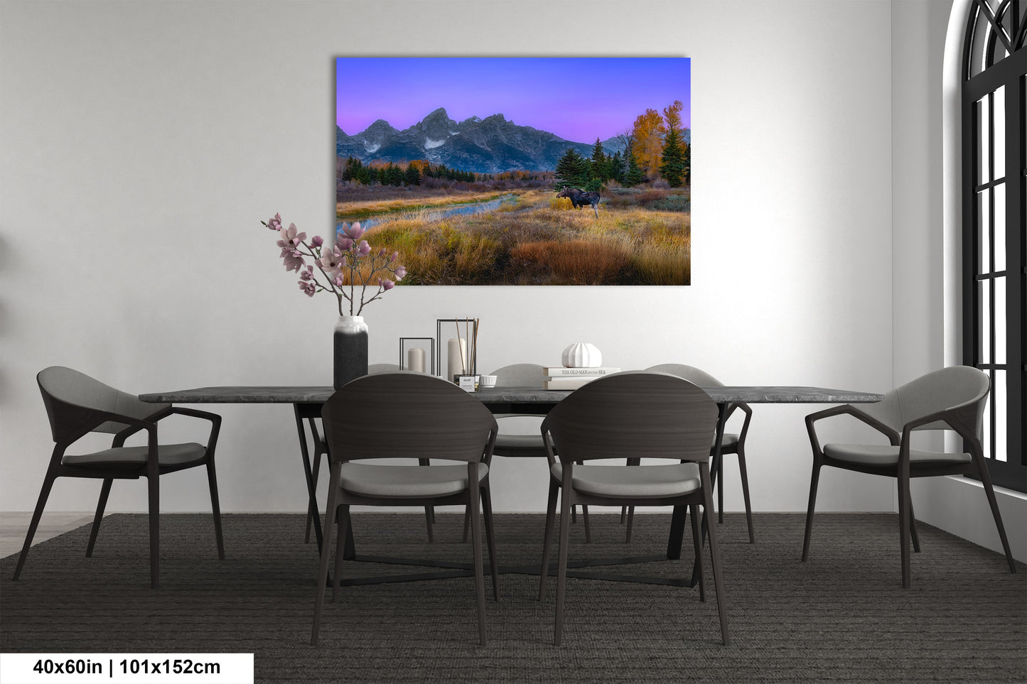 a dining room table with chairs and a painting on the wall