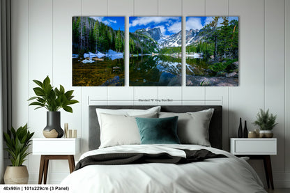 a bedroom with a bed and two paintings on the wall