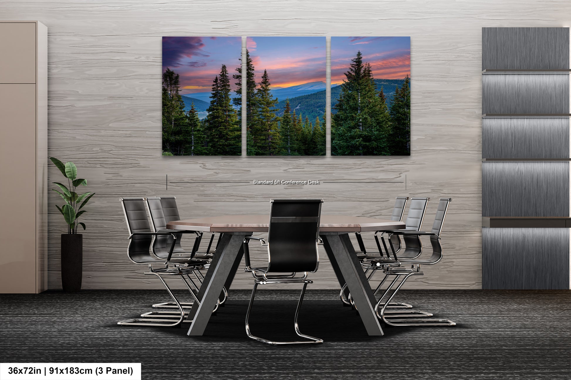 A modern office space with a large, three-panel landscape painting depicting a serene mountain scene with pine trees and a colorful sunset sky. The painting is mounted on a gray wall above a wooden table surrounded by black chairs.