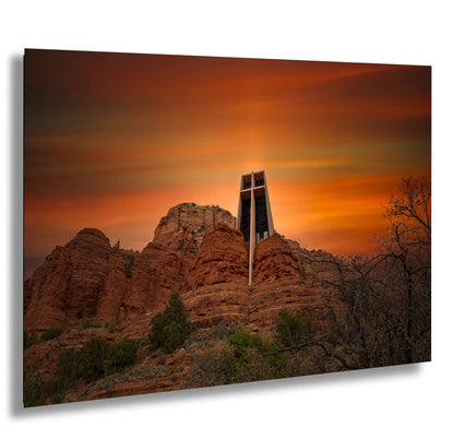 a cross on top of a mountain with a sunset in the background