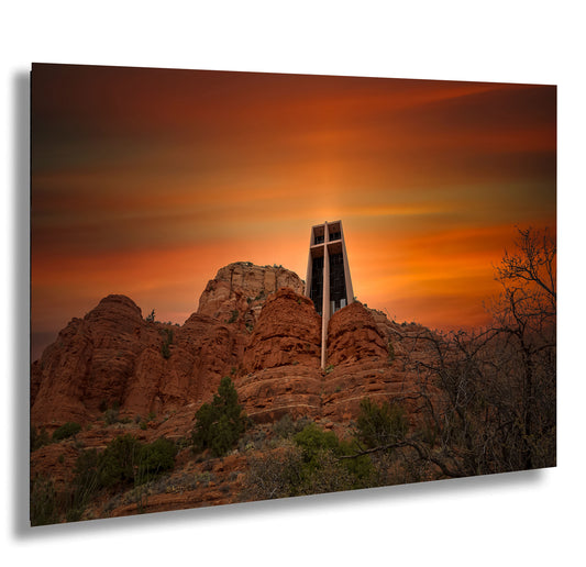 a cross on top of a mountain with a sunset in the background