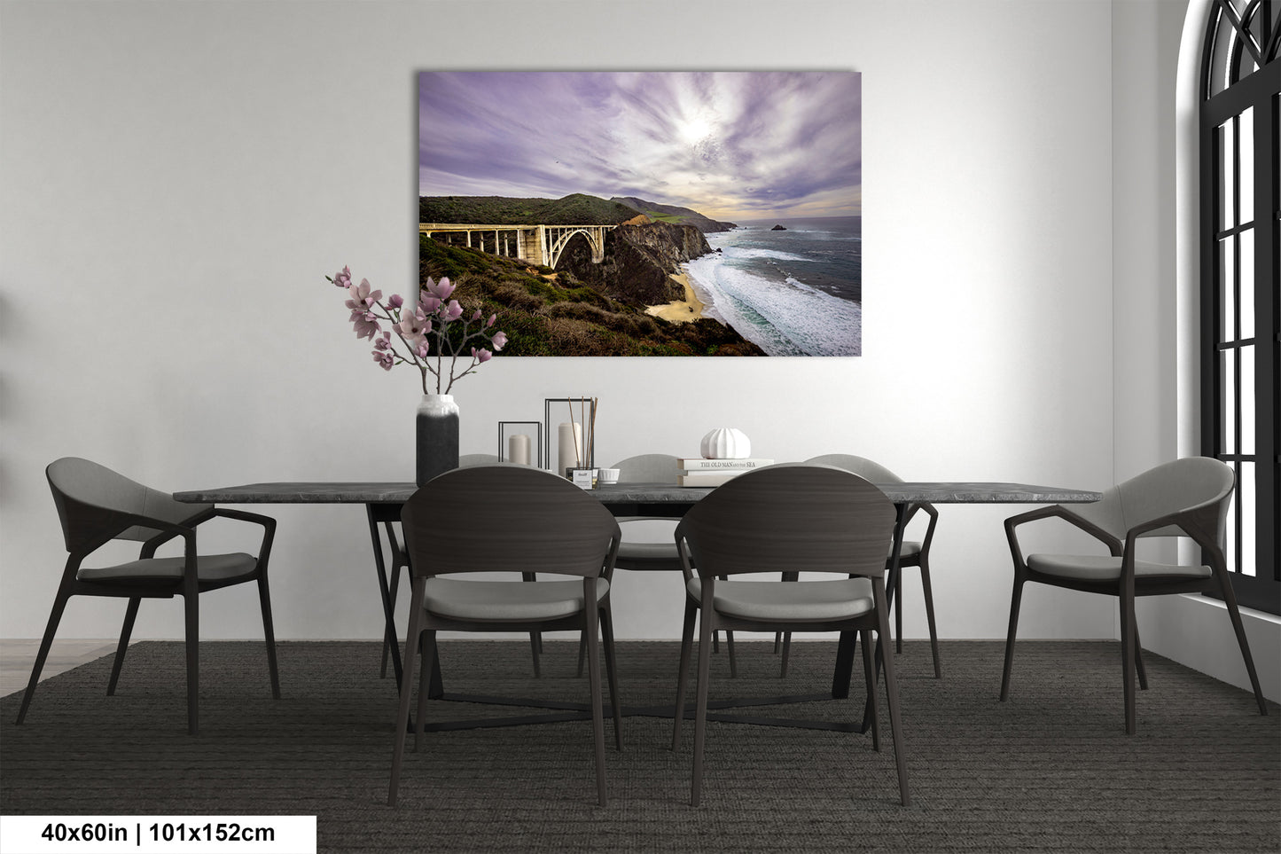 a dining room table with chairs and a painting on the wall