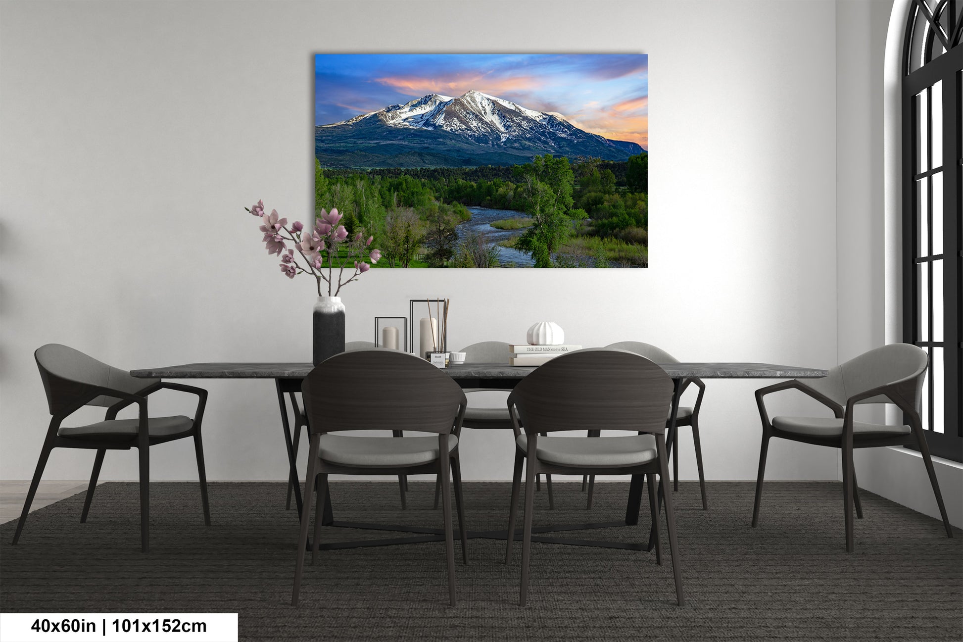 a dining room table with chairs and a painting on the wall