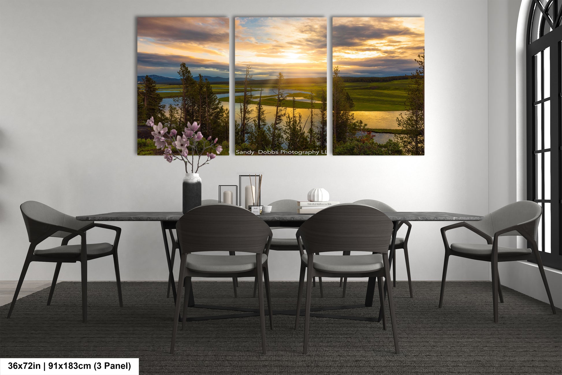 a dining room table with four chairs and a vase of flowers
