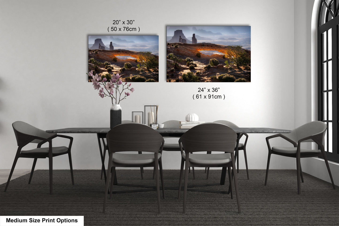 a dining table with four chairs and a vase of flowers