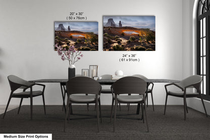 a dining table with four chairs and a vase of flowers