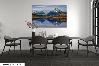a dining room table with chairs and a painting on the wall