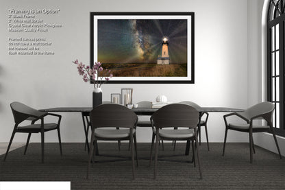 a dining room with a table and chairs and a picture hanging on the wall