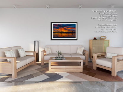 a modern living room with a large framed sunset painting hanging on the wall. The room is furnished with a sofa, two armchairs, and a coffee table, creating a comfortable and inviting atmosphere.