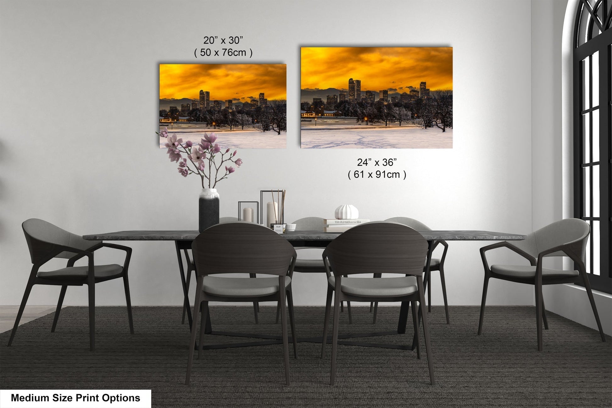 a dining table with four chairs and a vase with flowers