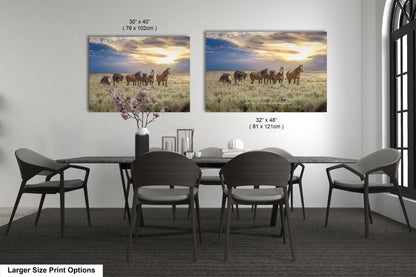 a dining room table with four chairs and two pictures of horses on the wall