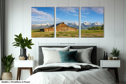 a bed room with a neatly made bed and three pictures on the wall