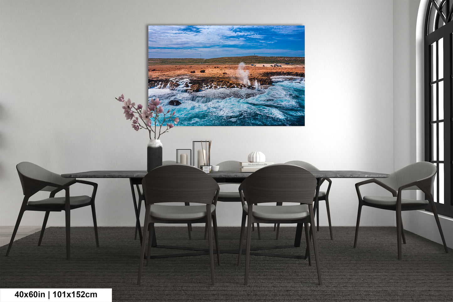 a dining room table with chairs and a painting on the wall