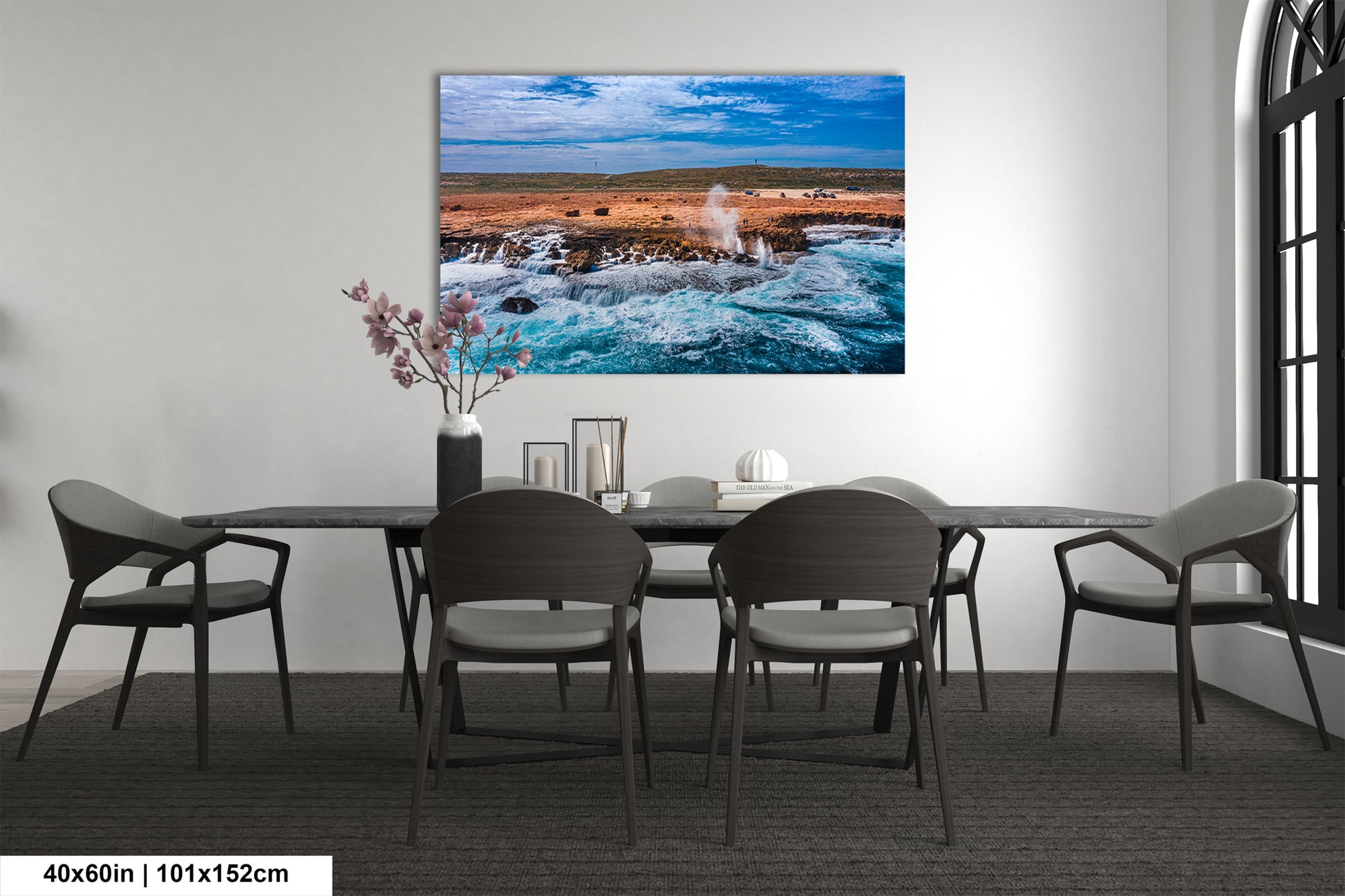 a dining room table with chairs and a painting on the wall
