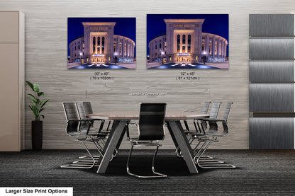 a modern office space with a large conference table and chairs, and two framed images of the Yankee Stadium in New York City displayed on the wall.