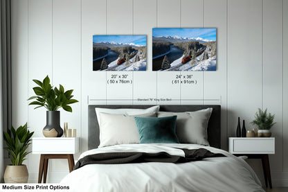 a bedroom with a bed, nightstands, and potted plants. There are two framed landscape photographs hanging on the wall above the bed, depicting snowy mountains and a train. The photographs are of medium size, with dimensions of 20 x 30" (50 x 70") and 24 x 36" (61 x 91") respectively.