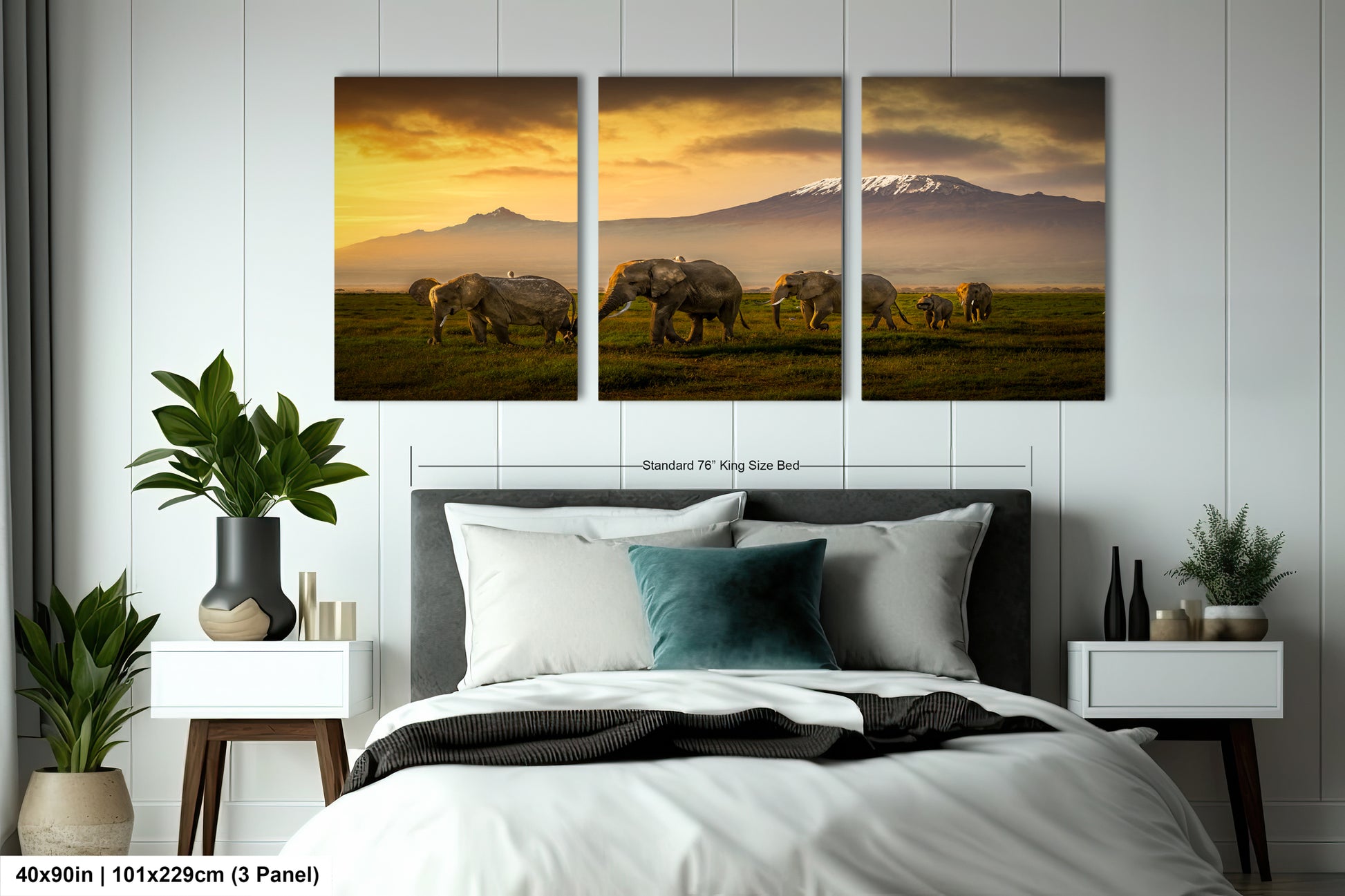 three elephants grazing in a field with a mountain in the background