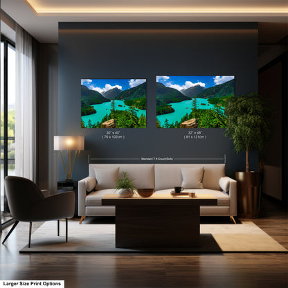 a modern living room with a large wall art depicting a scenic mountain landscape with a lake. The wall art is framed and hangs above a white sofa, which is positioned in front of a coffee table. The room also includes a chair, a lamp, and a potted plant, creating a cozy and inviting atmosphere.