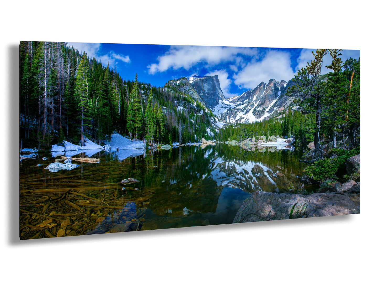 a lake surrounded by trees and snow covered mountains