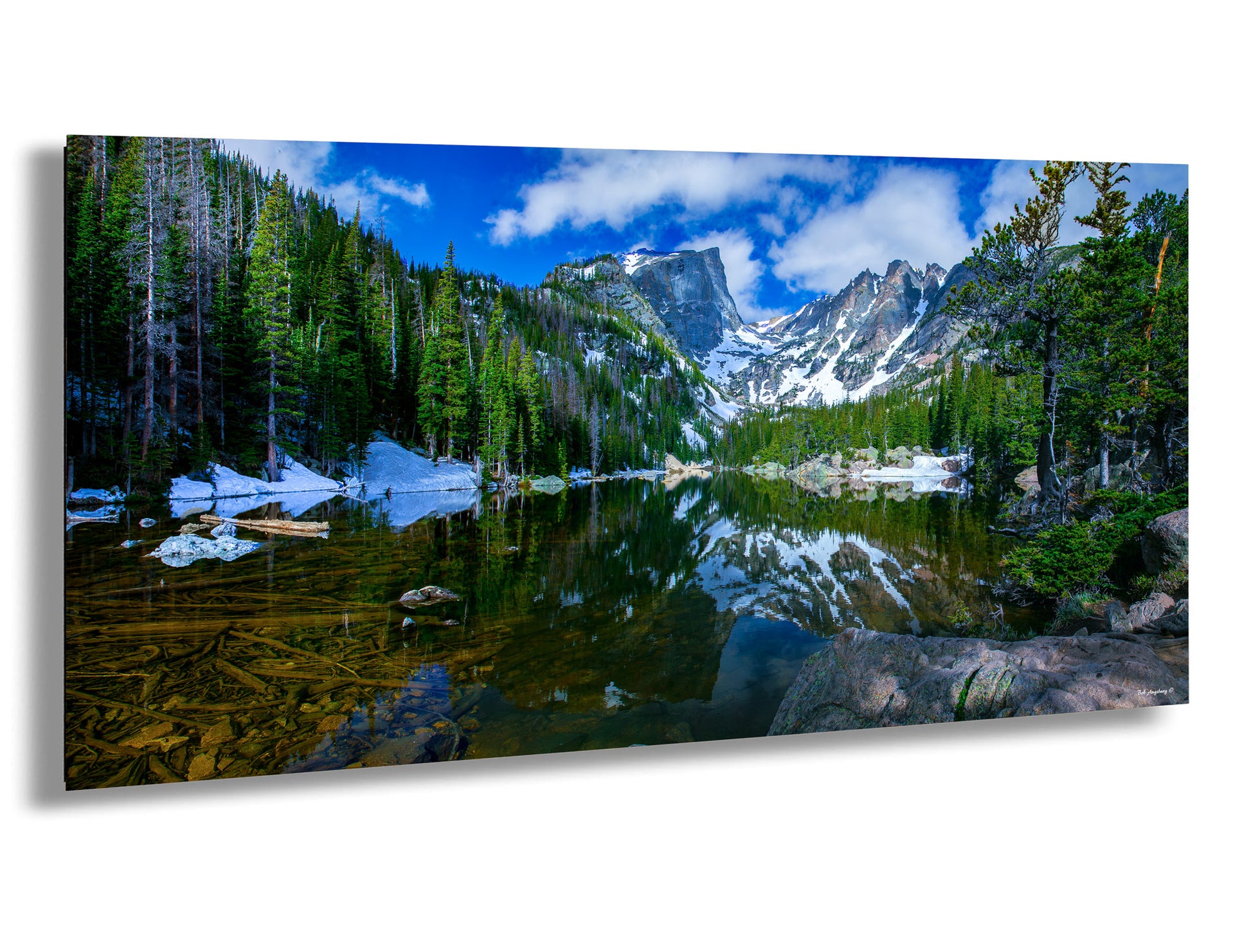 a lake surrounded by trees and snow covered mountains